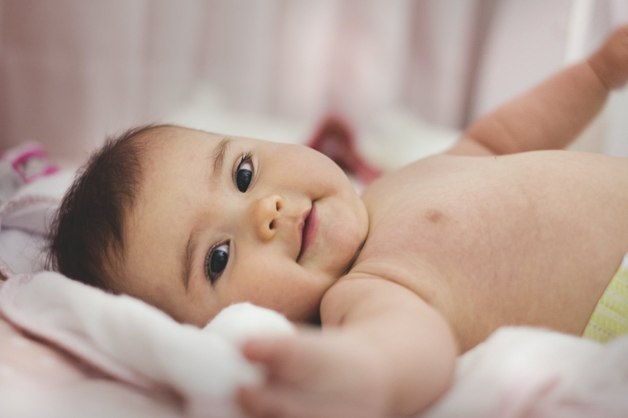 Baby Lying on Pink Bed